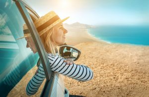 Young woman enjoying drive along coastline. 