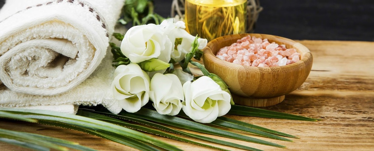 still shot of spa products, including a towel and pink salts